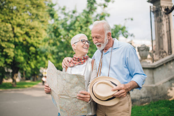 istock Elderly couple smiling and looking at each other while holding a map 997548778