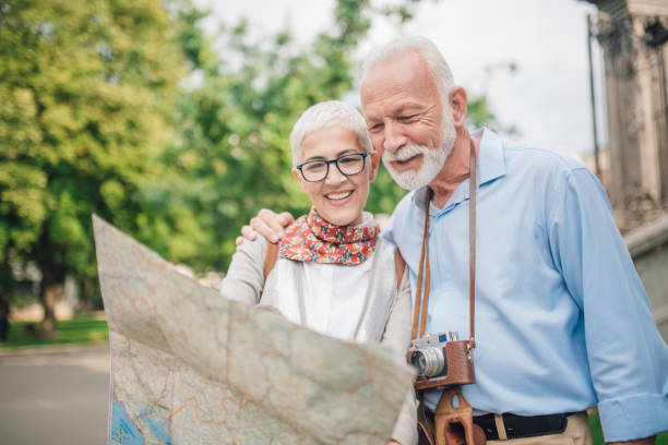 istock Couple in love hugging and looking at touristic map 997548868