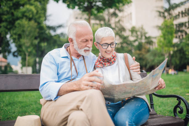 istock Elderly couple hugging on the bench and looking at the map 997548920