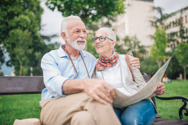 istock Senior couple sitting on the bench and use touristic map 997548946