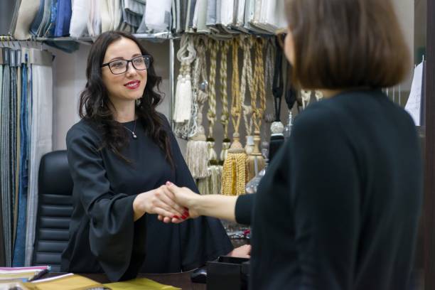 istock Woman designer, interior decorator smiles and greets with the client. Small business textile store. 997563548