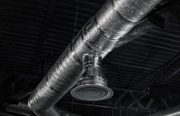 istock Ventilation system on the ceiling of large buildings. Ventilation pipes in silver insulation material hanging from the ceiling inside new building. 997563952