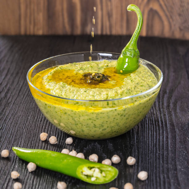 olio d'oliva versa sull'hummus - salad green pouring dip foto e immagini stock