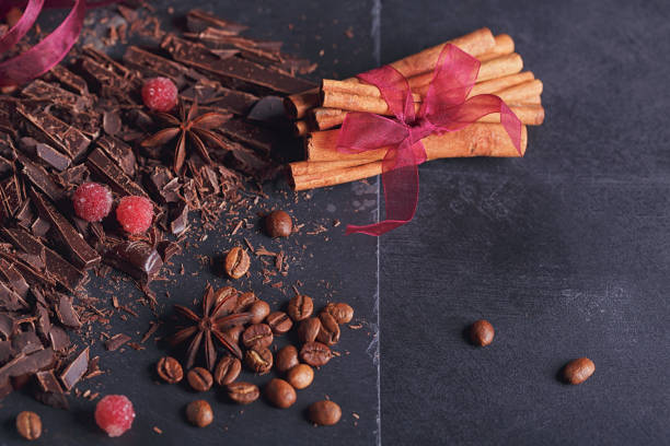 istock Dark chopping chocolate, black roasted coffee beans, red berries on dark background 997575240