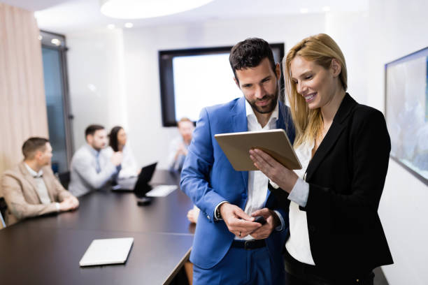 istock Attractive business couple using tablet in their company 997584378
