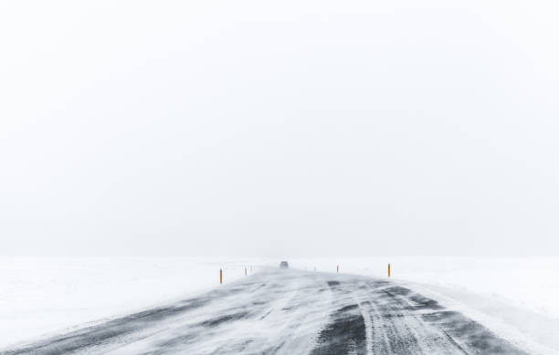 istock Lonely car on frozen road covered with snow 997585394