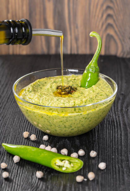 olio d'oliva versa sull'hummus - salad green pouring dip foto e immagini stock