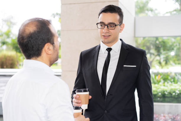 istock Confident young executive in glasses talking to his colleague 997593792