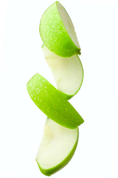 Pieces of an apple in flight on a white background, isolated