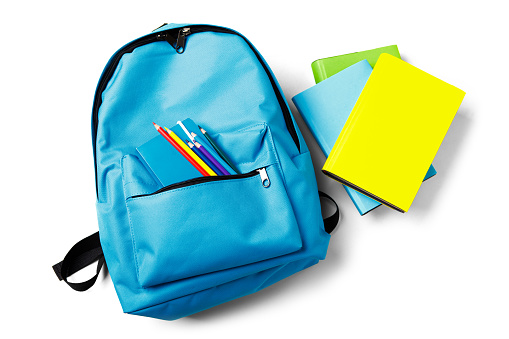 Backpack with school supplies, isolated on white.