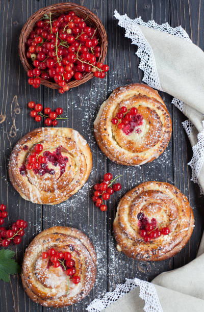 istock Fresh yeast buns with cheese and berries on wooden background. 997612406