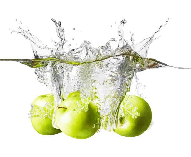istock Three fresh green apples splashing into clear water 997613298