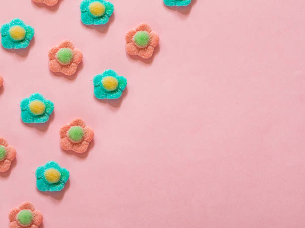 istock Pink and blue flower jelly candies pattern on pink background with copy space 997615686