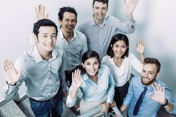istock Joyful Business Team Waving on Office Stairway 997625162