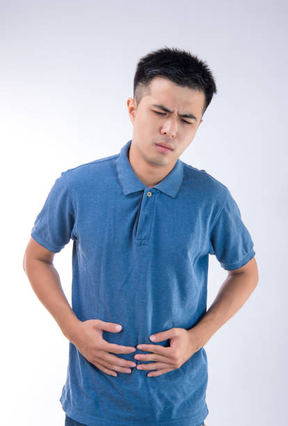 istock Man putting his hands for belly or stomach ache on white background 997626290