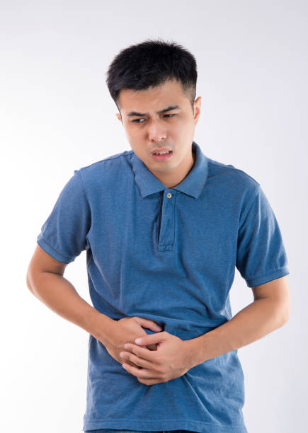 istock Man putting his hands for belly or stomach ache on white background 997626586
