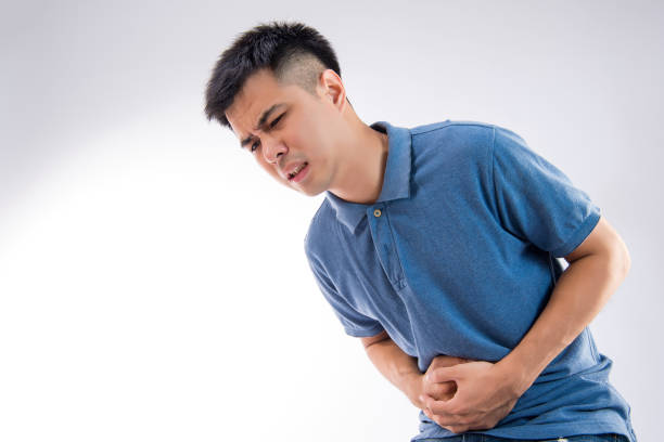 istock Man putting his hands for belly or stomach ache on white background 997629126
