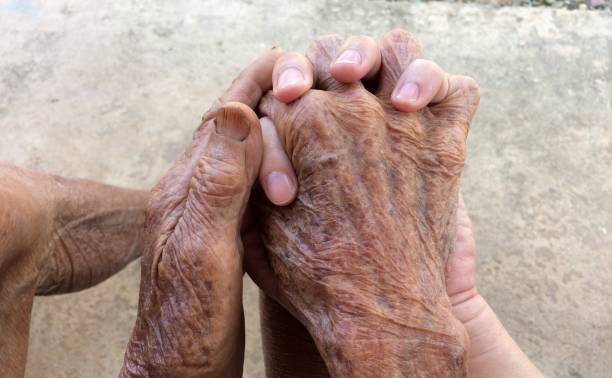 istock Hand of the old man holding young man hand. 997637554