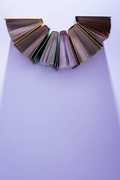 istock elevated view of stack of books in half circle on violet table 997638560