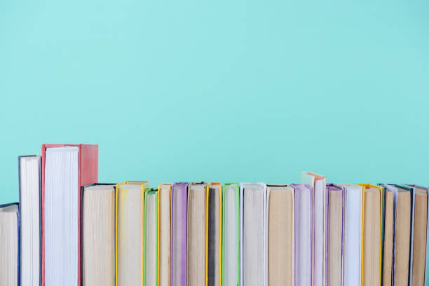 istock row of different colored books isolated on blue 997639112