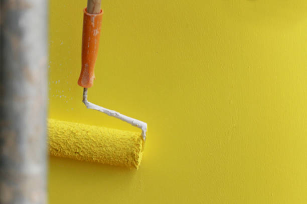 istock Painting hand with paintbrush yellow 997643496