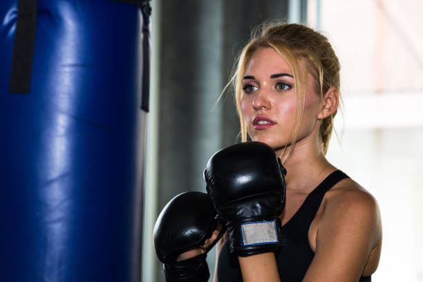istock Young female punching a bag with boxing glove 997656122