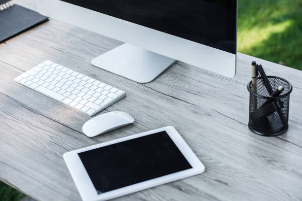 istock selective focus of digital tablet and computer with blank screens at table outdoors 997656524