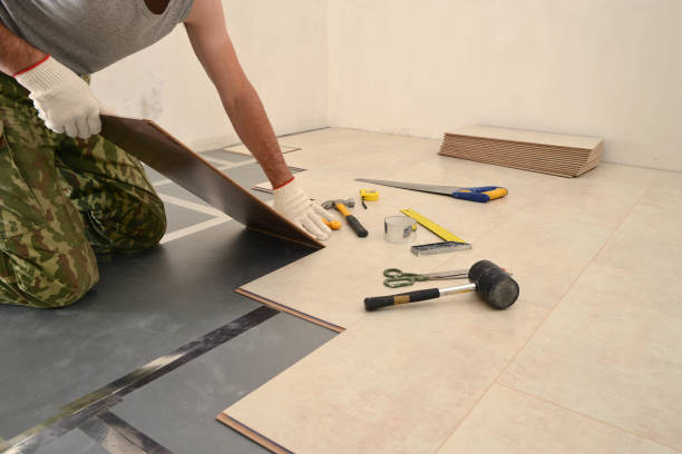 istock Carpenter worker installing wood parquet board during flooring w 997666772