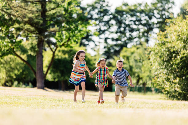 istock Three happy kids holding hands and running 997673212