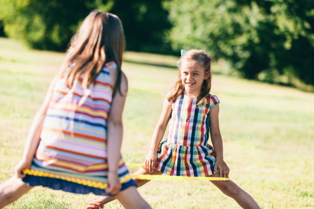 istock Two girls standing with an elastic wrapped around their legs. 997673230