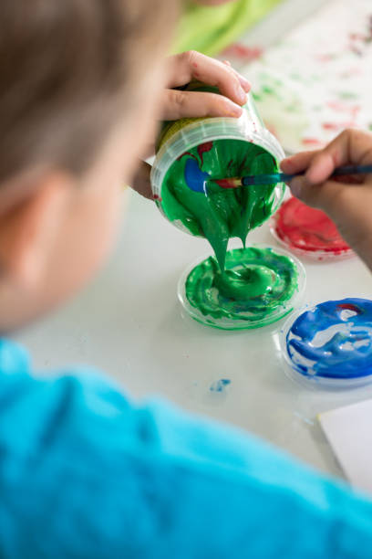 istock Little boy mixing paints for his art class 997678216
