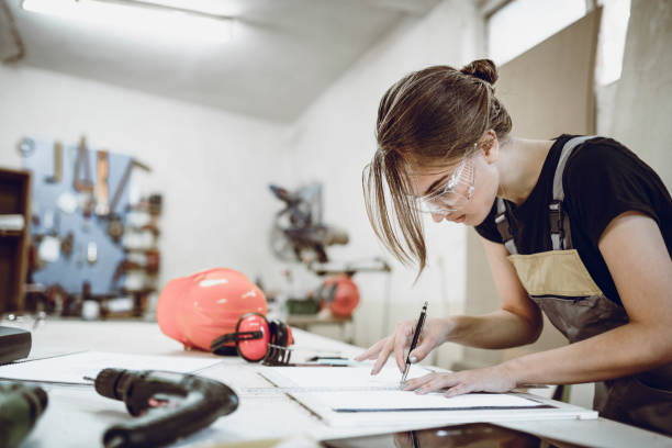 Female Carpenter Sketching And Designing New Parts In Workshop stock photo
