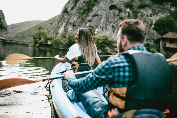 istock Couple Synchronizing Oaring During Kayaking On Mountain Lake 997679468