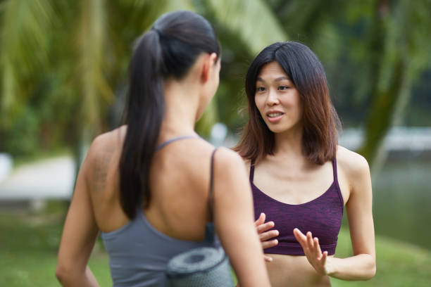 istock Two multi-ethnic friends talking after doing yoga at park 997692348