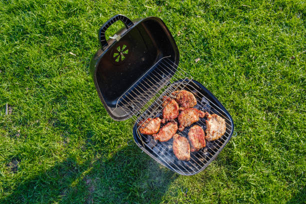 istock Barbecue grill with various kinds of meat. Placed on grass 997693038