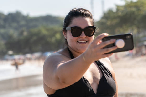 istock Plus Size Woman Taking a Selfie at the beach 997693162