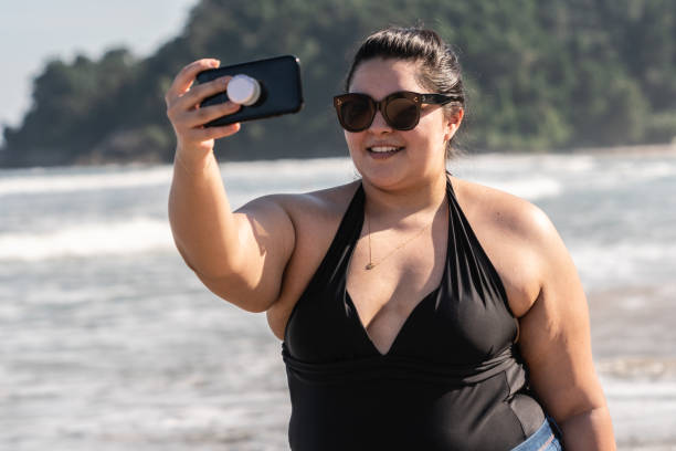 istock Plus Size Woman Taking a Selfie at the beach 997693902