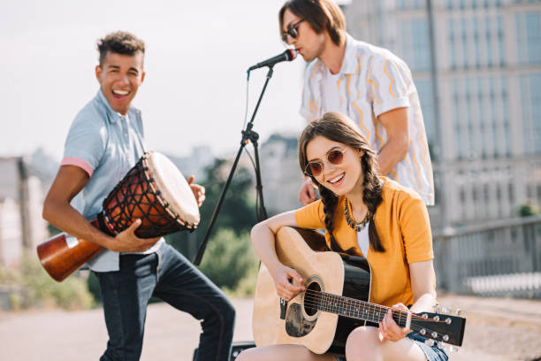 istock Multiracial young people performing om different musical instruments on street 997705560