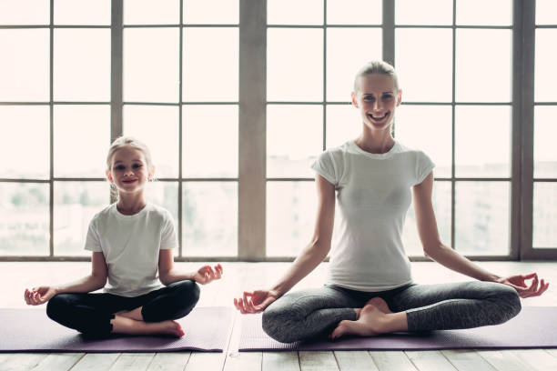 istock Mom with daughter working out at home 997705604
