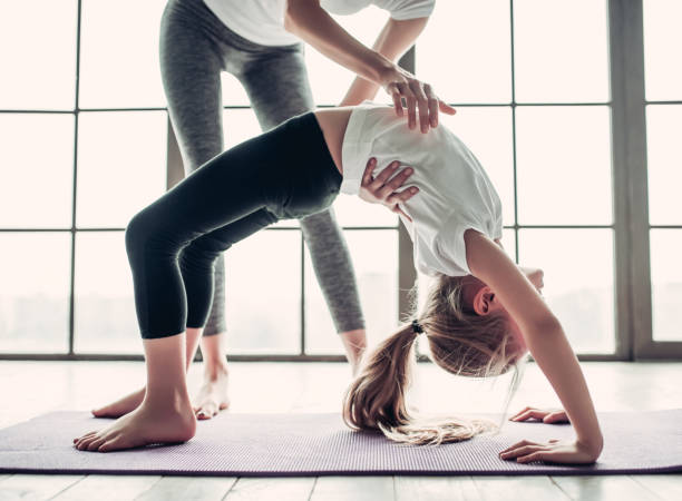 istock Mom with daughter working out at home 997705696