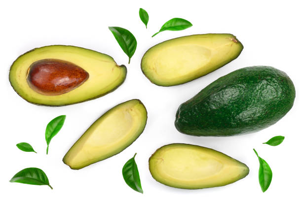istock whole and half avocado decorated with green leaves isolated on white background. Top view. Flat lay 997709954