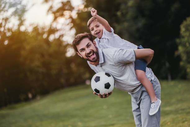 istock Dad with son playing football, soccer 997710360