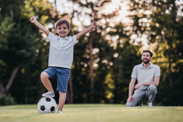 istock Dad with son playing football, soccer 997710578