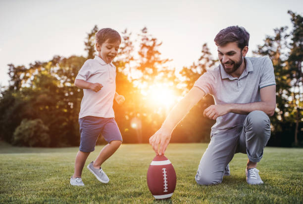 pai com o filho jogando futebol americano - simple living rural scene lifestyles nature - fotografias e filmes do acervo