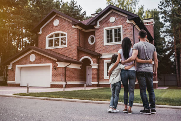 Happy family outdoors Back view of happy family is standing near their modern house and hugging two parents stock pictures, royalty-free photos & images