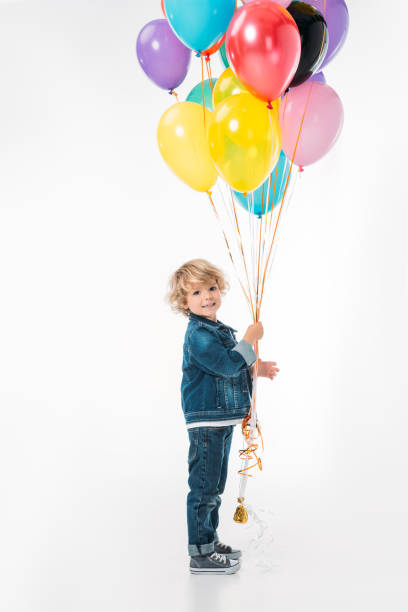 istock smiling adorable boy with bundle of balloons isolated on white 997719148
