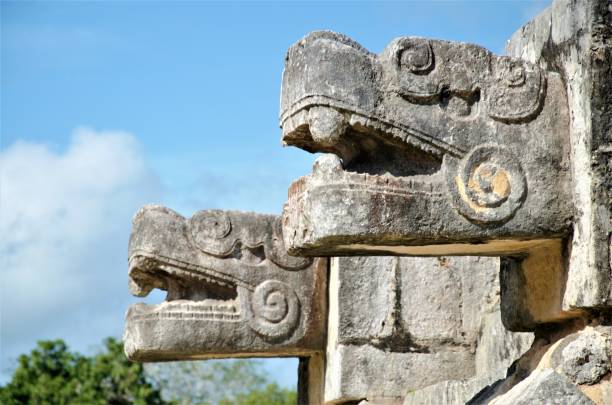 Snakes Sculptures in Chichen Itza Yucatan Mexico Chichen Itza, in the city of Pisté, in Yucatán, Mexico, was one of the most important centers of the Mayan culture. The largest and most important structure of Chichen Itza is the Kukulkan Temple, which is also known as El Castillo. It dominates the area with its elegance, and symmetry, and it's the most famous attraction to this archeological site. Great sculptures of Plumed Serpents run down the sides of the staircases, and are set off by shadows from the corner tiers on the Spring and Fall equinox. kukulkan pyramid photos stock pictures, royalty-free photos & images