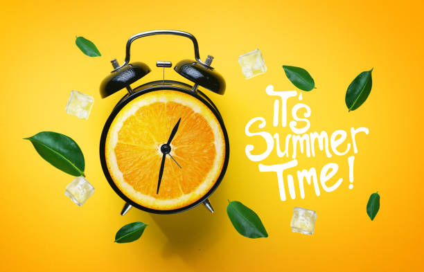 it's summer time typography. alarm clock of orange fruit green leaves and ice cube flying around on yellow background - clock time alarm clock orange imagens e fotografias de stock