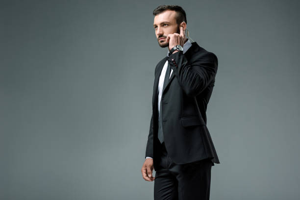 istock Handsome security guard listening message with security earpiece isolated on grey 997746982