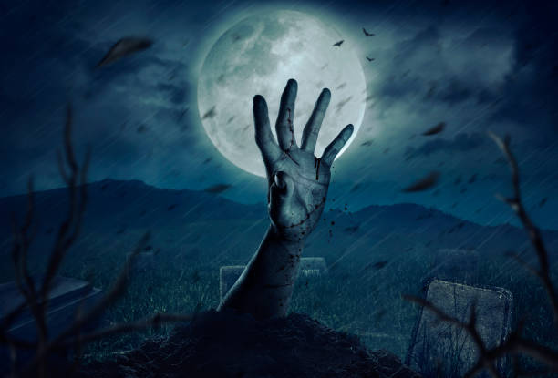 istock Zombie hands rising in dark Halloween night. 997750830